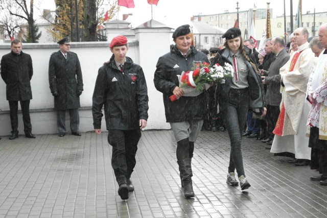 zdjęcie: składanie kwiatów przy tablicy Marszałka Piłsudskiego